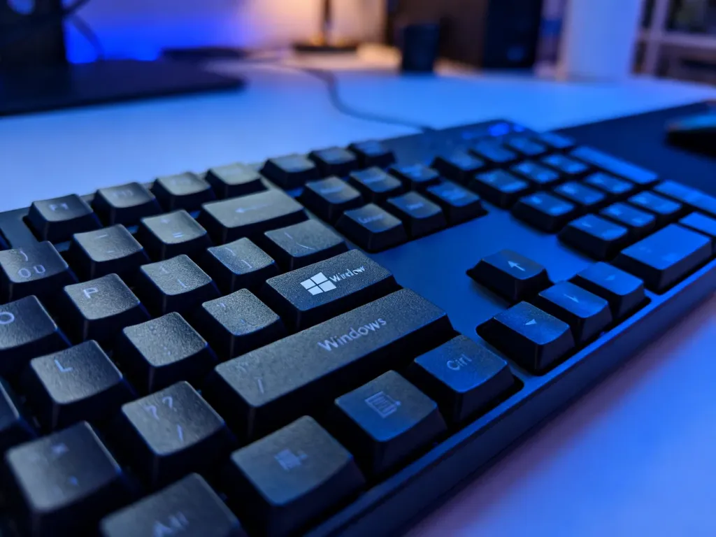 Zbliżenie na klawisz Windows na podświetlanej klawiaturze mechanicznej w domowym biurze.
